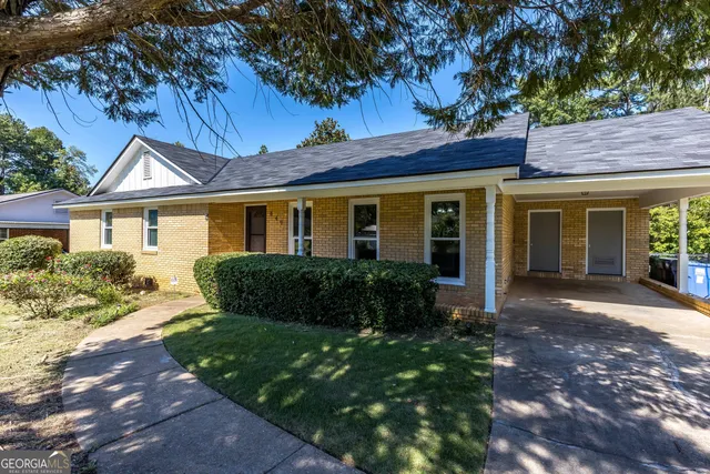 a front view of a house with a garden
