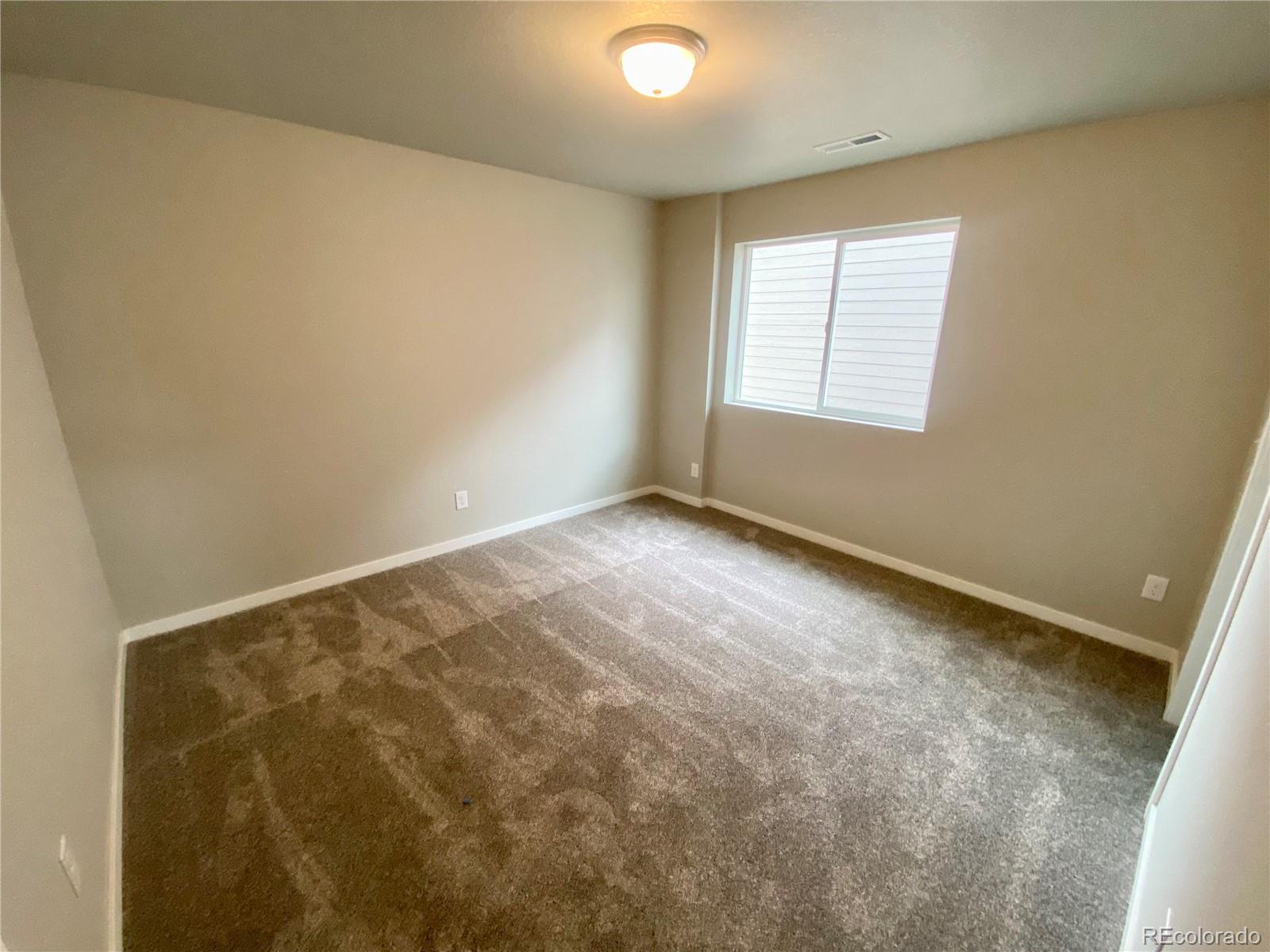 517 Ryan Avenue Fort Lupton, CO 80621 - Photo 13 of 21 an empty room with windows