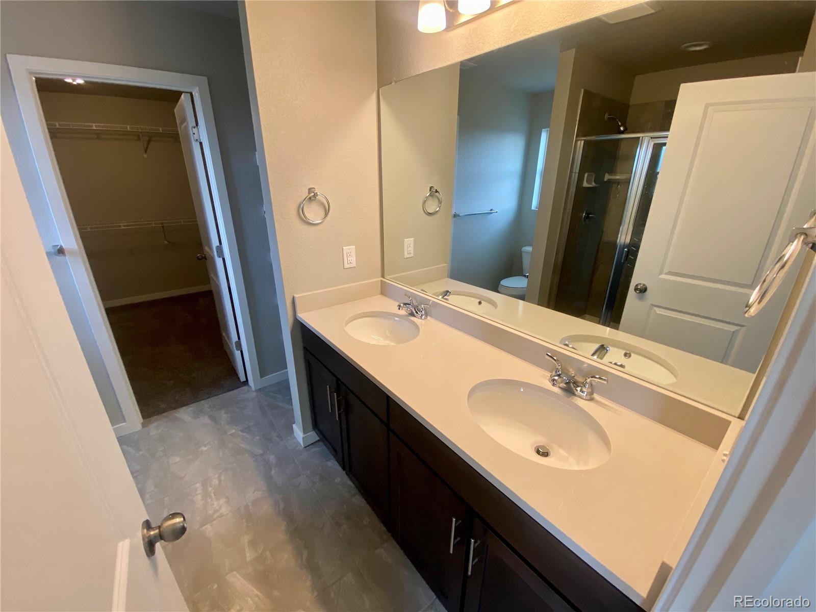 517 Ryan Avenue Fort Lupton, CO 80621 - Photo 18 of 21 a bathroom with a double vanity sink and a mirror
