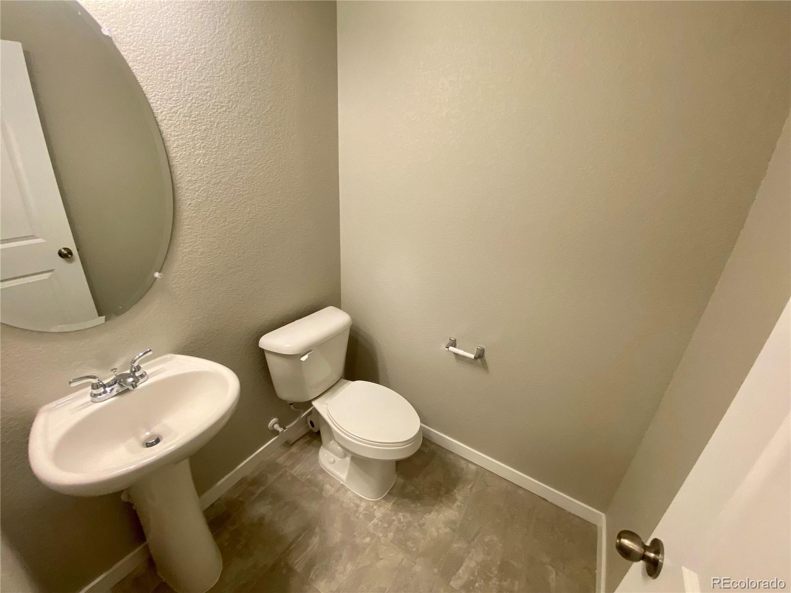 517 Ryan Avenue Fort Lupton, CO 80621 - Photo 7 of 21 a bathroom with a toilet sink and mirror
