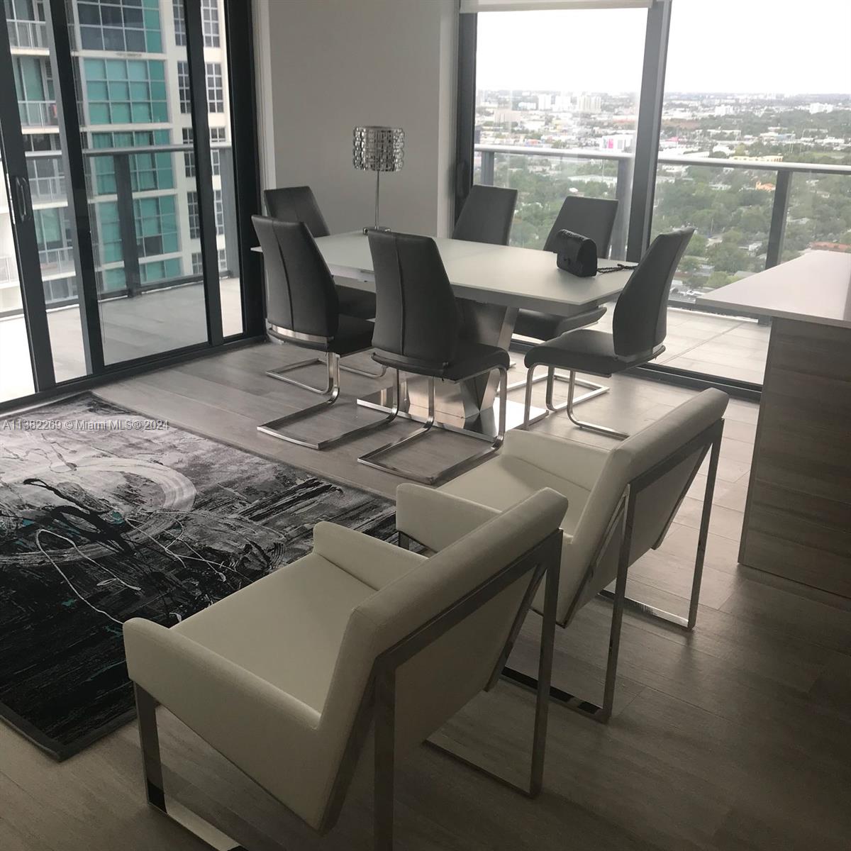 121 Northeast 34th Street, Unit 2601 Miami, FL 33137 - Photo 6 of 10 a dining room with furniture and a floor to ceiling window