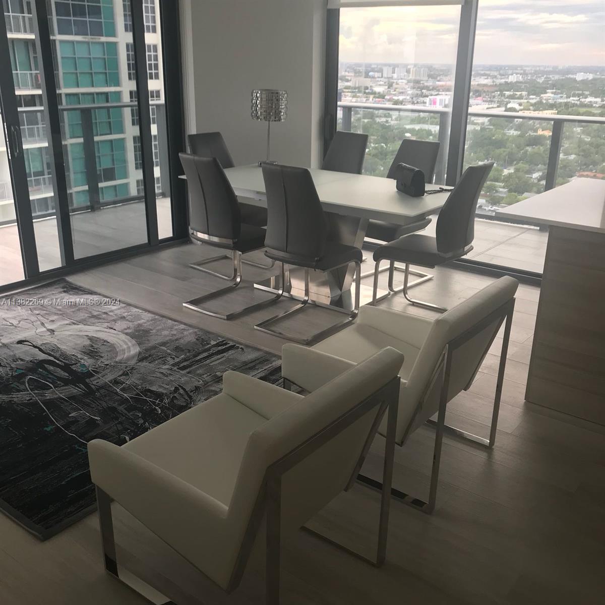 121 Northeast 34th Street, Unit 2601 Miami, FL 33137 - Photo 9 of 10 a dining room with furniture and a floor to ceiling window