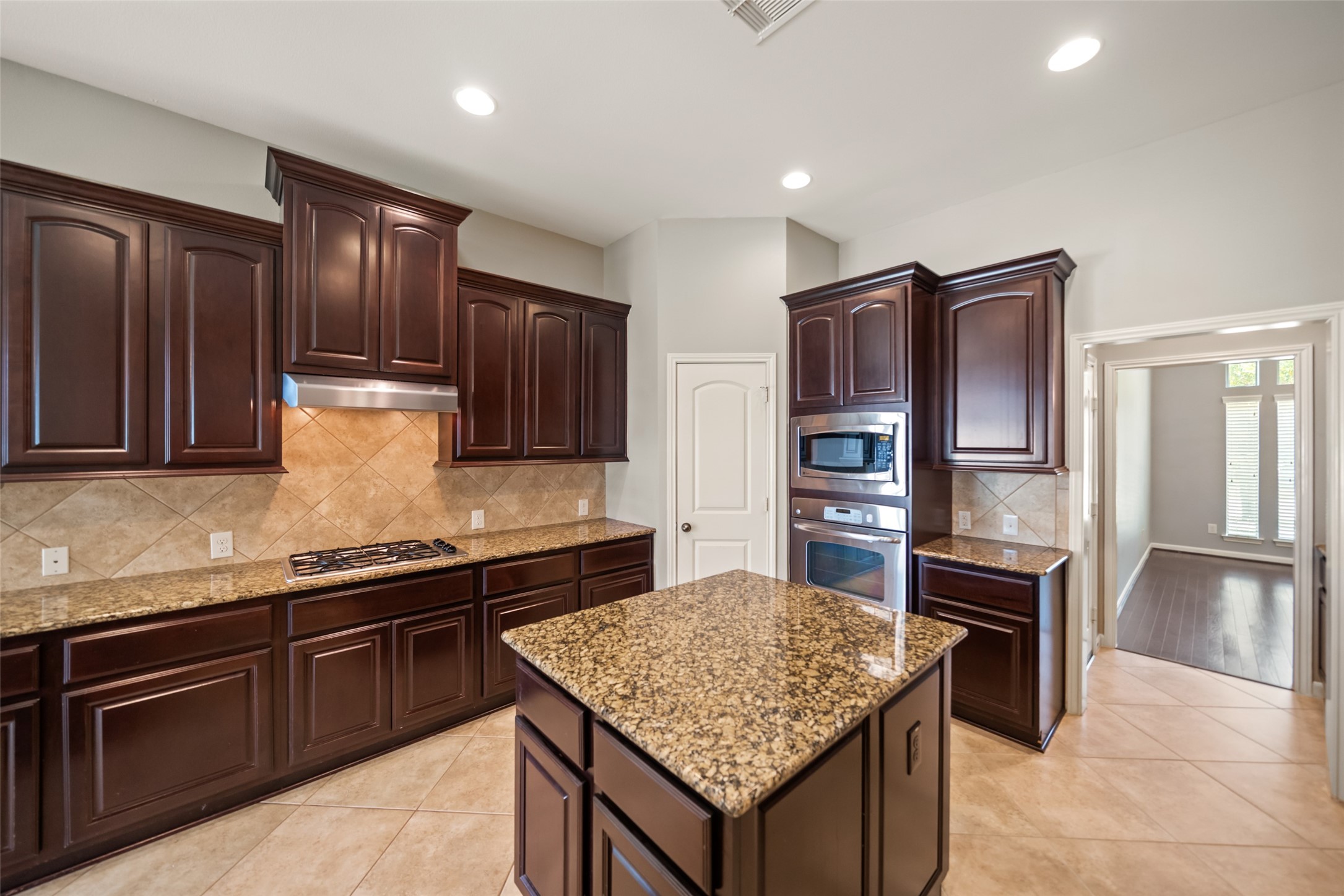 2818 Red Maple Drive Katy, TX 77494 - Photo 12 of 50 a kitchen with stainless steel appliances granite countertop wooden cabinets a stove and a refrigerator