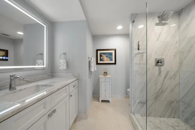 a bathroom with a granite countertop sink mirror and shower