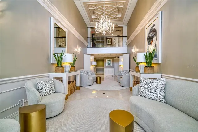 a living room with furniture a chandelier and a flat screen tv