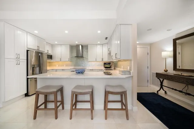 a kitchen with refrigerator a sink and chairs