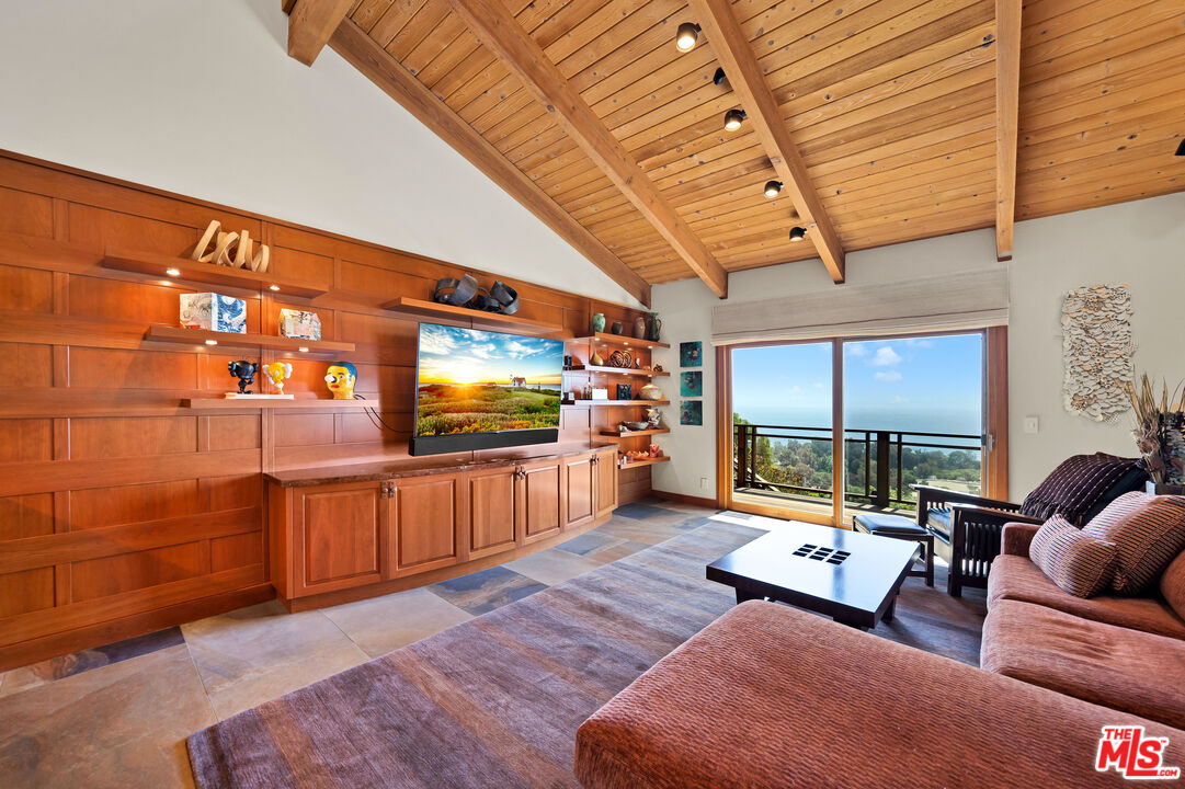 27434 Winding Way Malibu, CA 90265 - Photo 14 of 39 a living room with furniture a flat screen tv and kitchen view