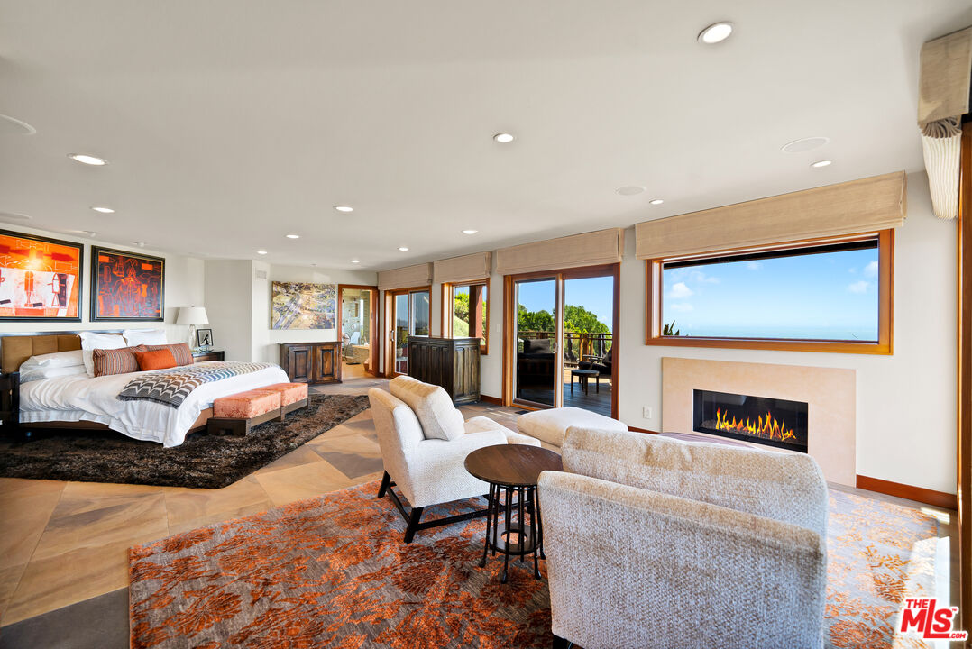 27434 Winding Way Malibu, CA 90265 - Photo 17 of 39 a spacious bedroom with a large bed and a fireplace