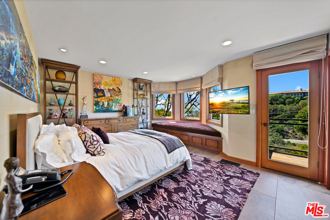 27434 Winding Way Malibu, CA 90265 - Photo 21 of 39 a bedroom with a large bed and a window