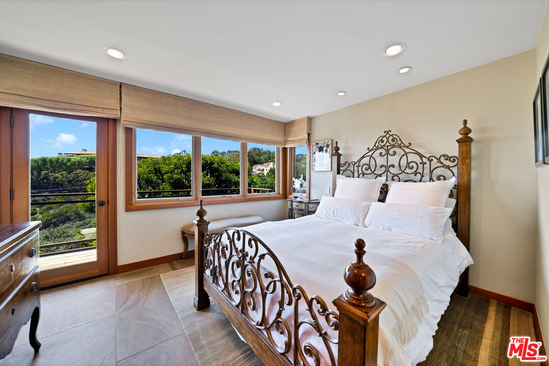 27434 Winding Way Malibu, CA 90265 - Photo 23 of 39 a bed room with a bed and a large window