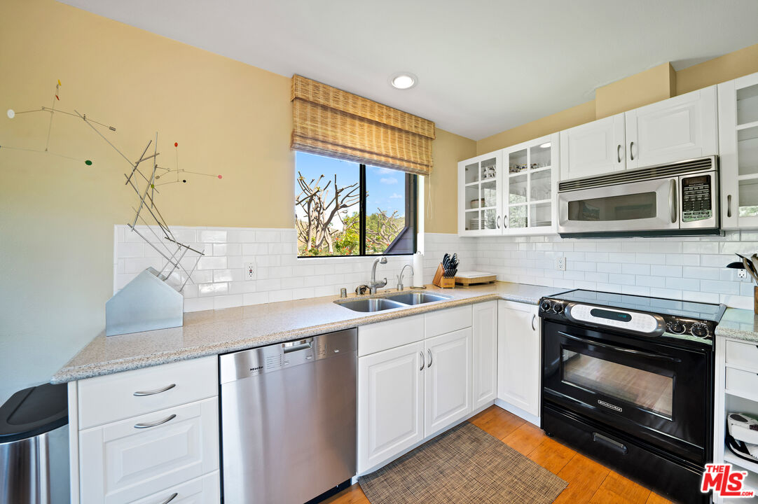 27434 Winding Way Malibu, CA 90265 - Photo 28 of 39 a kitchen with stainless steel appliances a stove sink and microwave