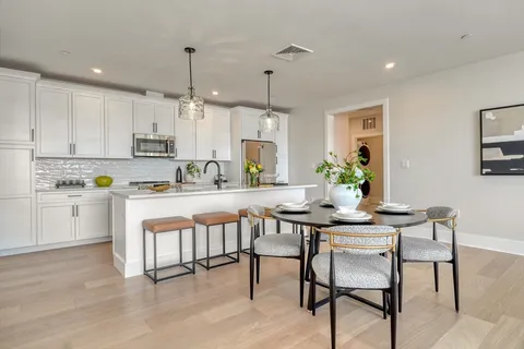a kitchen with white cabinets and white appliances