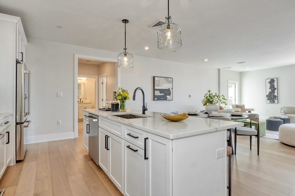 62 Foundry Street, Unit 309 Wakefield, MA 01880 - Photo 6 of 36 a kitchen with stainless steel appliances granite countertop kitchen island a white cabinets and a chandelier