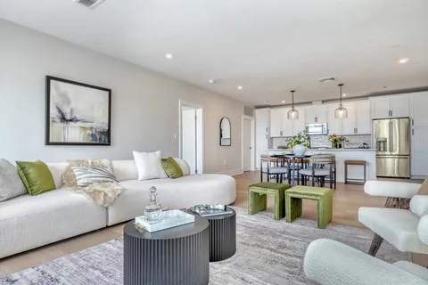 a living room with furniture and kitchen view