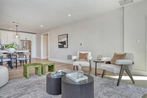 a living room with furniture a rug and white walls