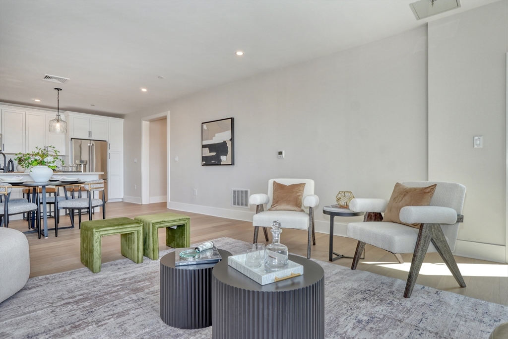 62 Foundry Street, Unit 309 Wakefield, MA 01880 - Photo 9 of 36 a living room with furniture a rug and white walls
