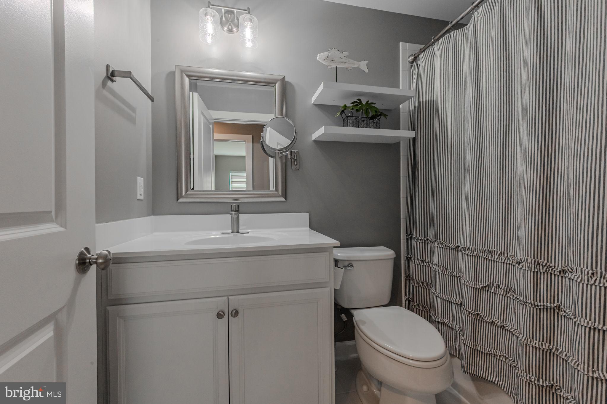 100 Anglers Road, Unit A4 Lewes, DE 19958 - Photo 13 of 57 a bathroom with a granite countertop sink toilet and a mirror