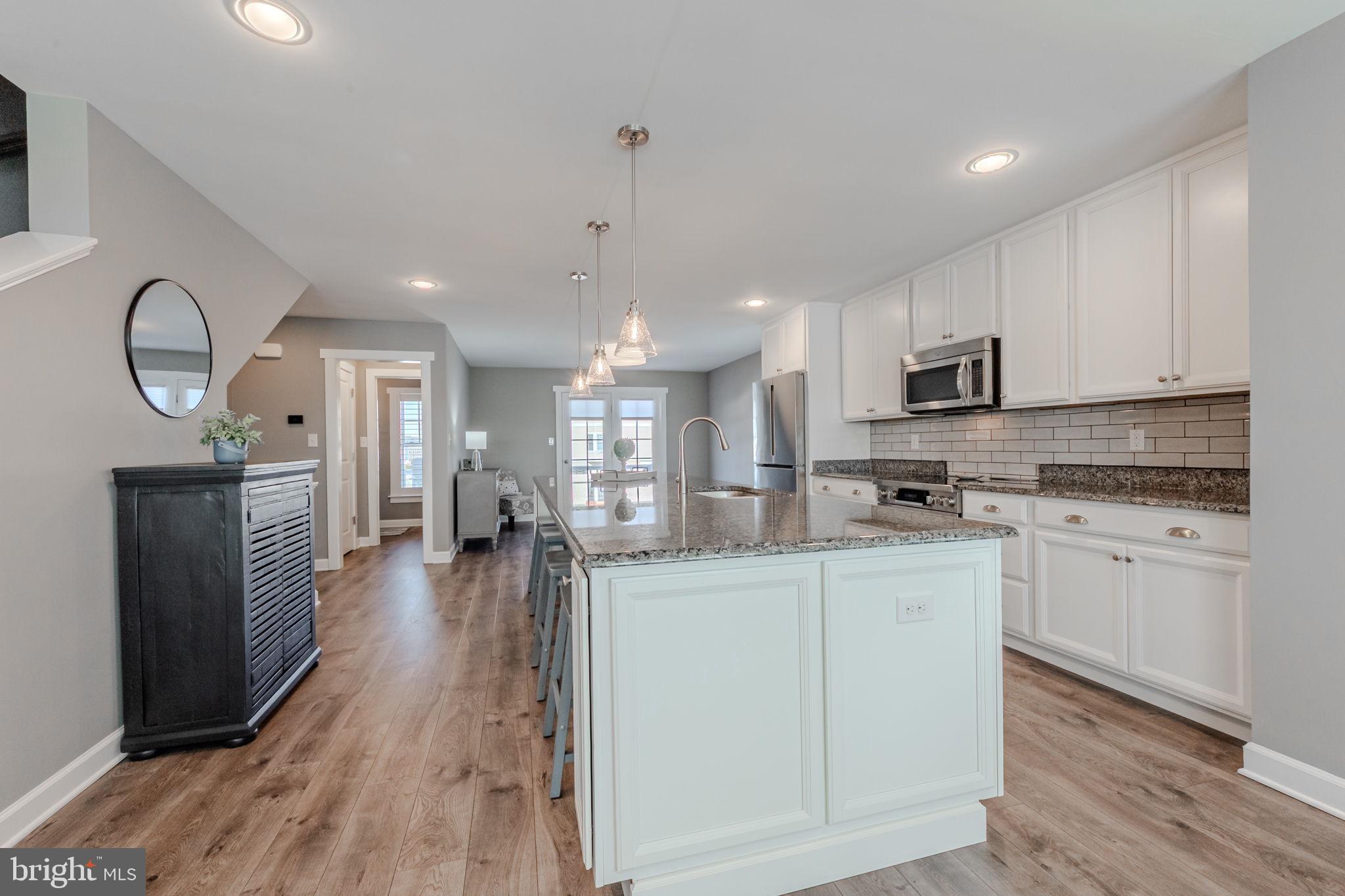 100 Anglers Road, Unit A4 Lewes, DE 19958 - Photo 21 of 57 a kitchen with stainless steel appliances granite countertop a sink refrigerator and cabinets