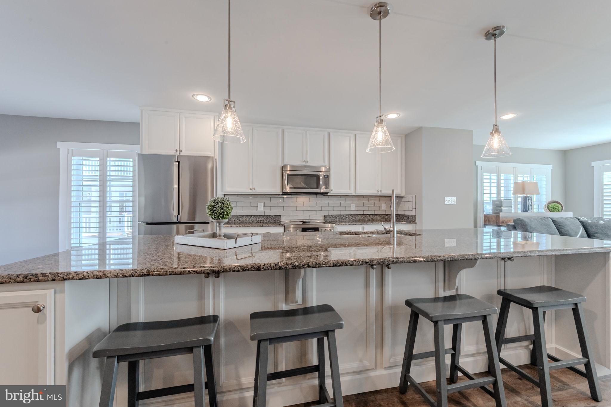 100 Anglers Road, Unit A4 Lewes, DE 19958 - Photo 23 of 57 a kitchen with stainless steel appliances granite countertop a sink a stove a center island and cabinets