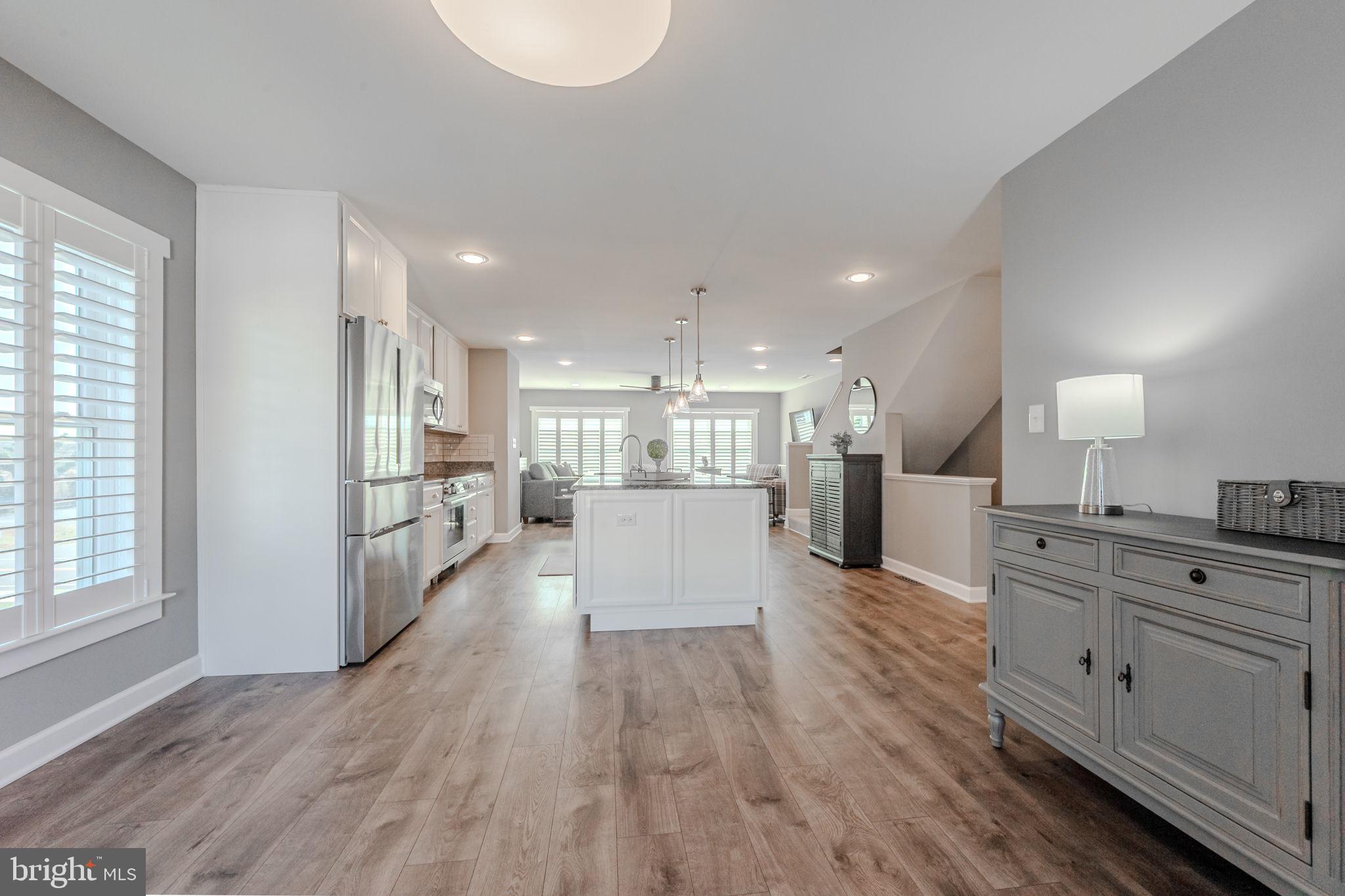 100 Anglers Road, Unit A4 Lewes, DE 19958 - Photo 26 of 57 a large kitchen with kitchen island a stove a refrigerator a sink dishwasher and a oven with wooden floor