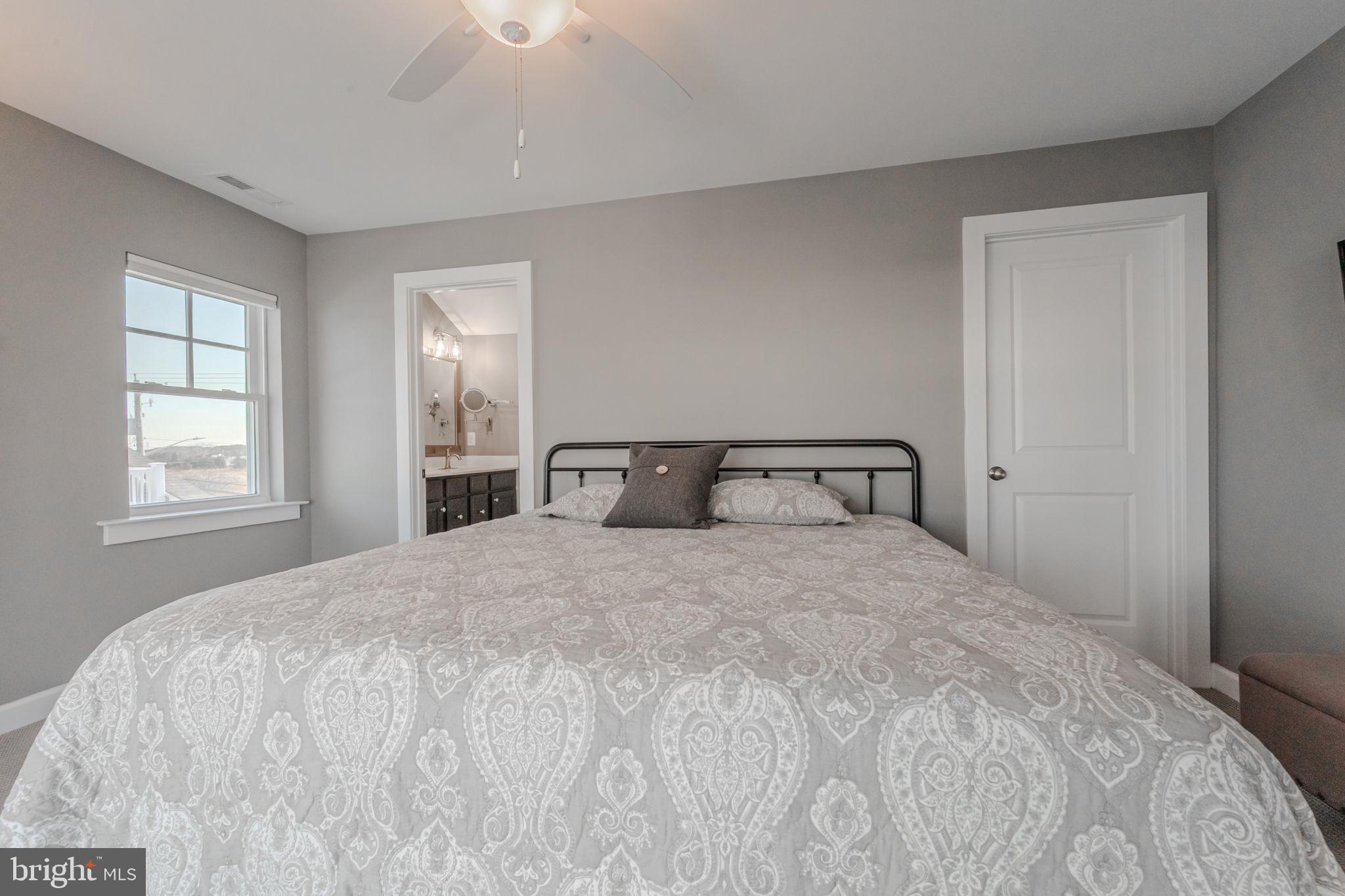 100 Anglers Road, Unit A4 Lewes, DE 19958 - Photo 35 of 57 a large bed sitting in a bedroom next to a window and chandelier