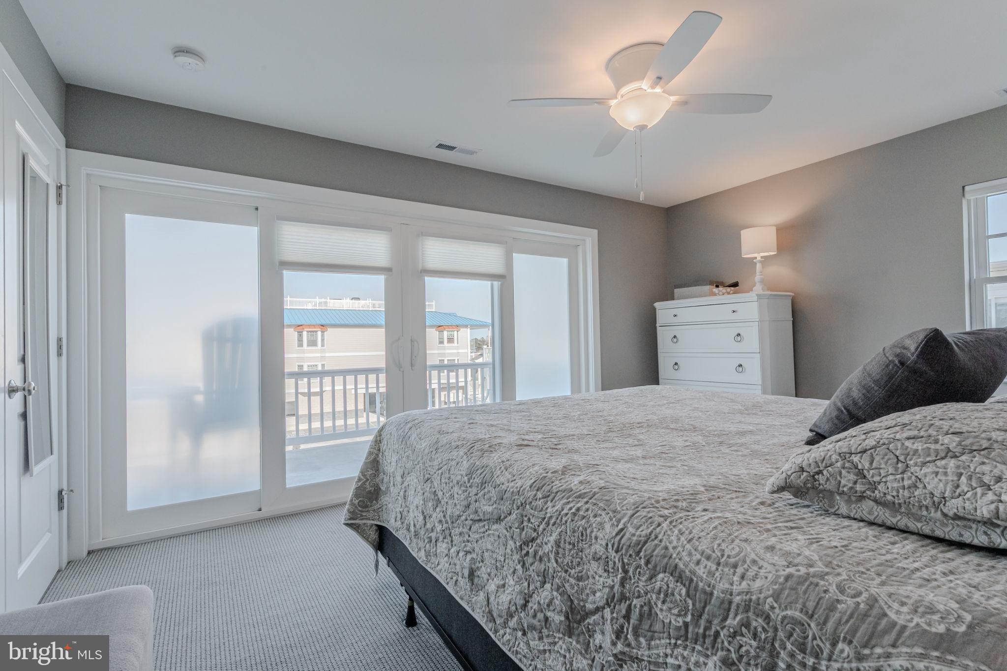 100 Anglers Road, Unit A4 Lewes, DE 19958 - Photo 37 of 57 a bedroom with a large bed and a chandelier fan
