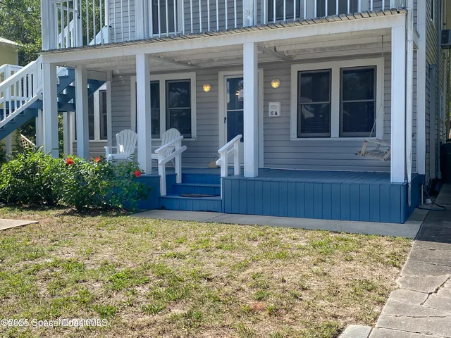 a view of brick house with potted plants