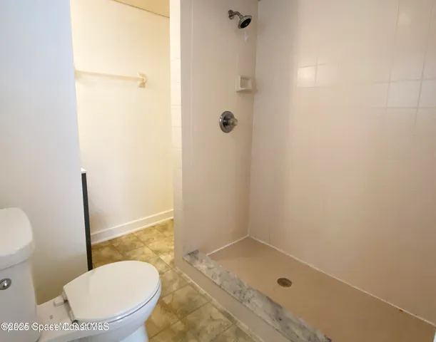 a bathroom with a granite countertop toilet and a sink