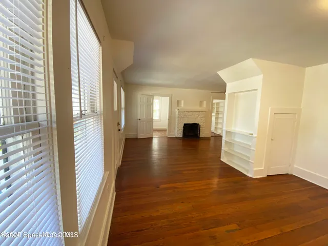 a view of a hallway with wooden floor and glass door