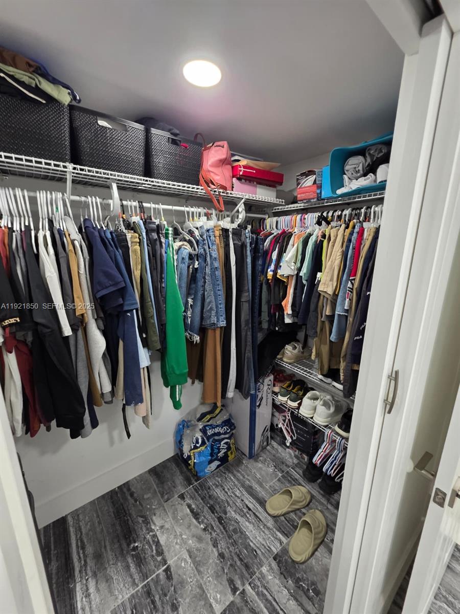 30232 Southwest 172nd Avenue Homestead, FL 33030 - Photo 19 of 31 a view of walk in closet with clothes