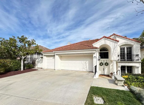 a view of a white house with yard and a large tree