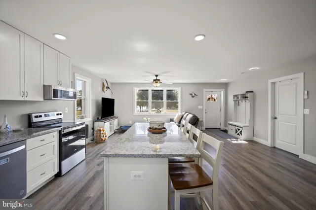 a open kitchen with stainless steel appliances granite countertop a stove and cabinets