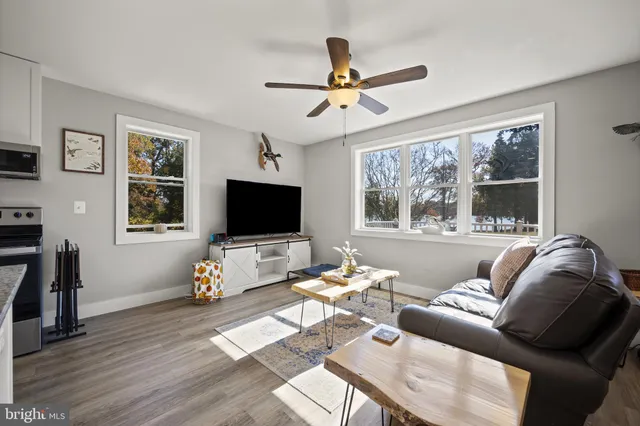 a living room with furniture a window and a flat screen tv