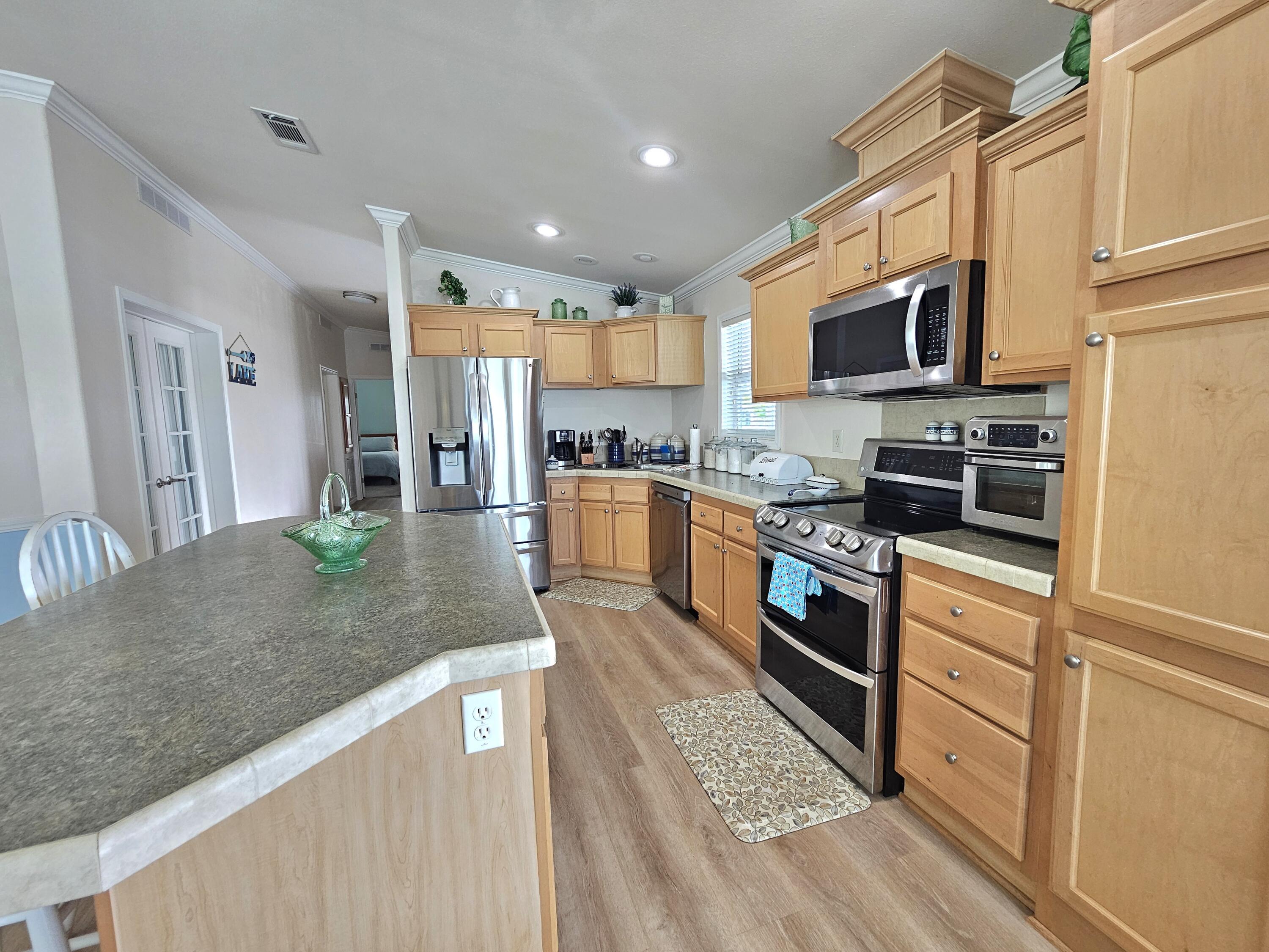 7902 Southeast 95th Trail Okeechobee, FL 34974 - Photo 12 of 36 a kitchen with stainless steel appliances granite countertop a refrigerator a stove top oven a sink and dishwasher