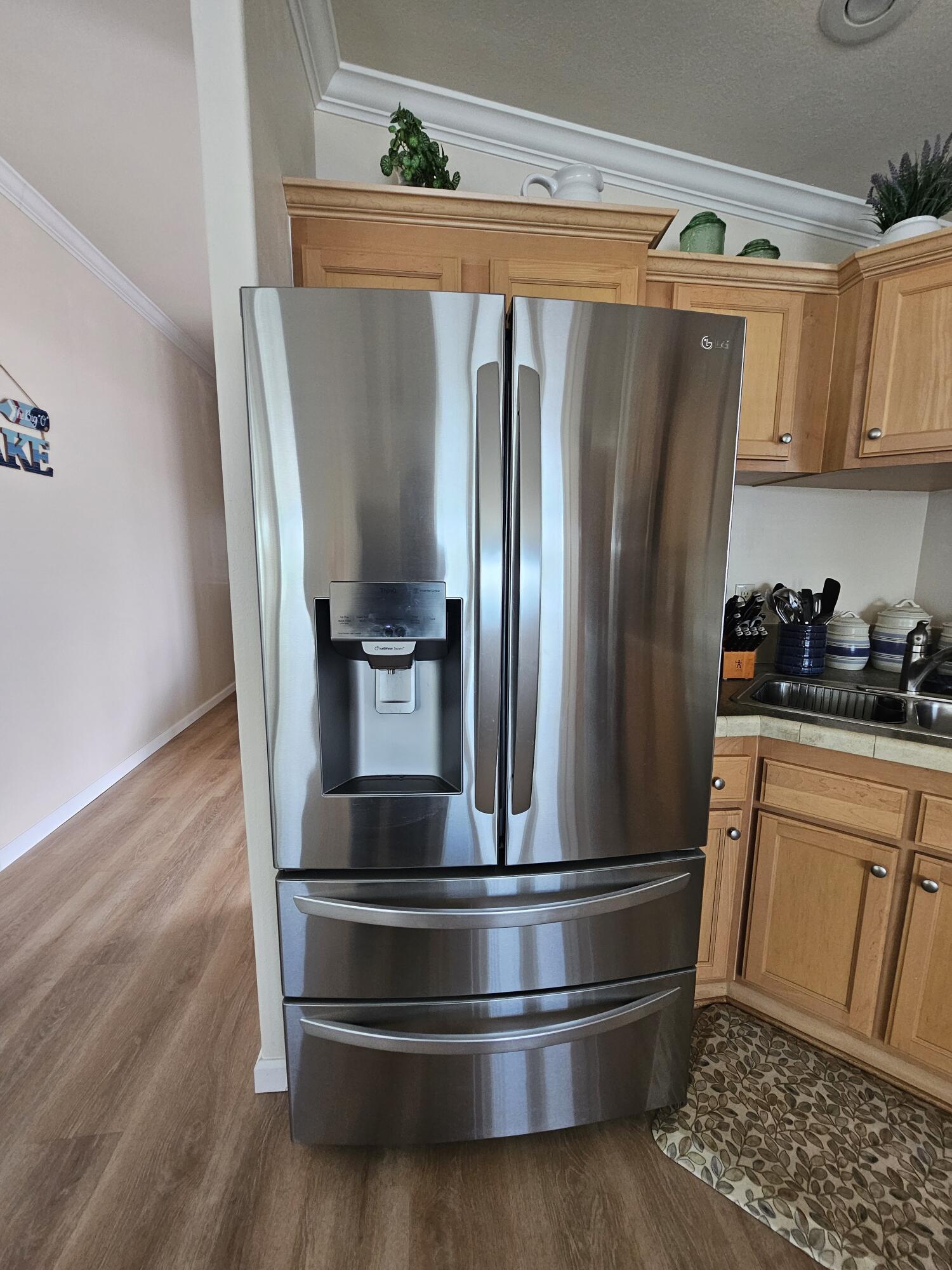 7902 Southeast 95th Trail Okeechobee, FL 34974 - Photo 15 of 36 a kitchen with stainless steel appliances a refrigerator and wooden floor