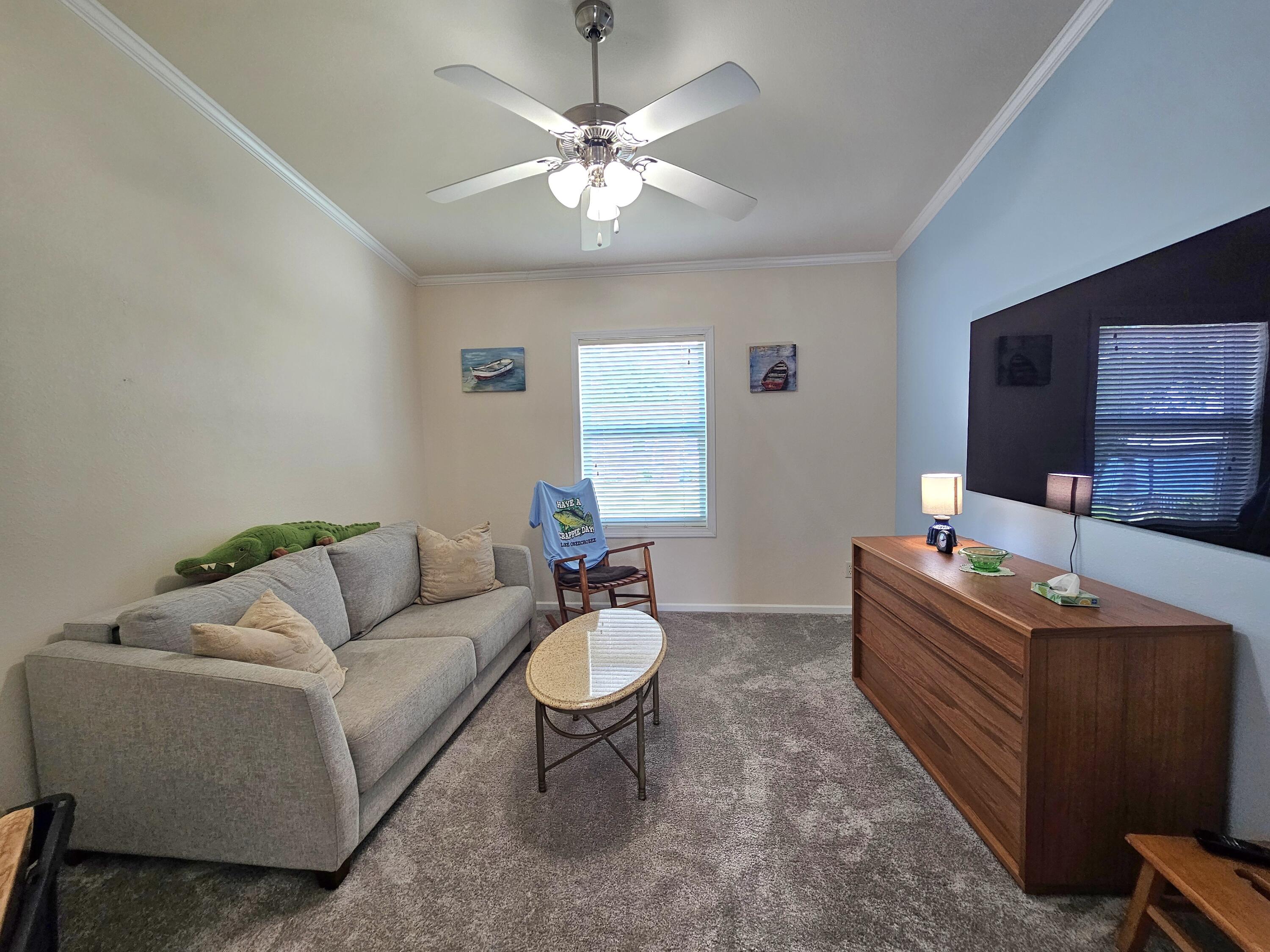 7902 Southeast 95th Trail Okeechobee, FL 34974 - Photo 17 of 36 a living room with furniture a chandelier and a window