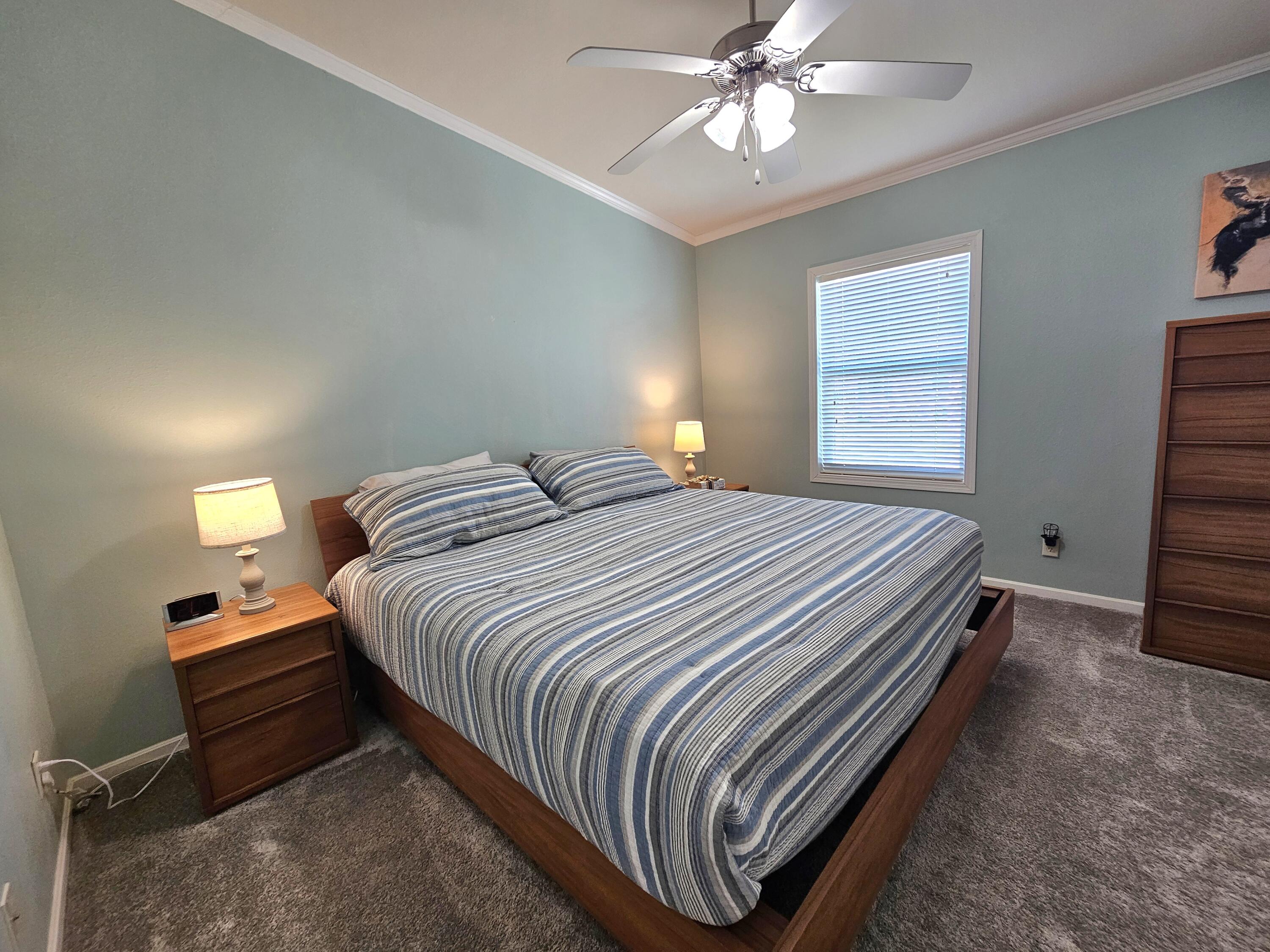 7902 Southeast 95th Trail Okeechobee, FL 34974 - Photo 18 of 36 a bedroom with a bed and a chandelier