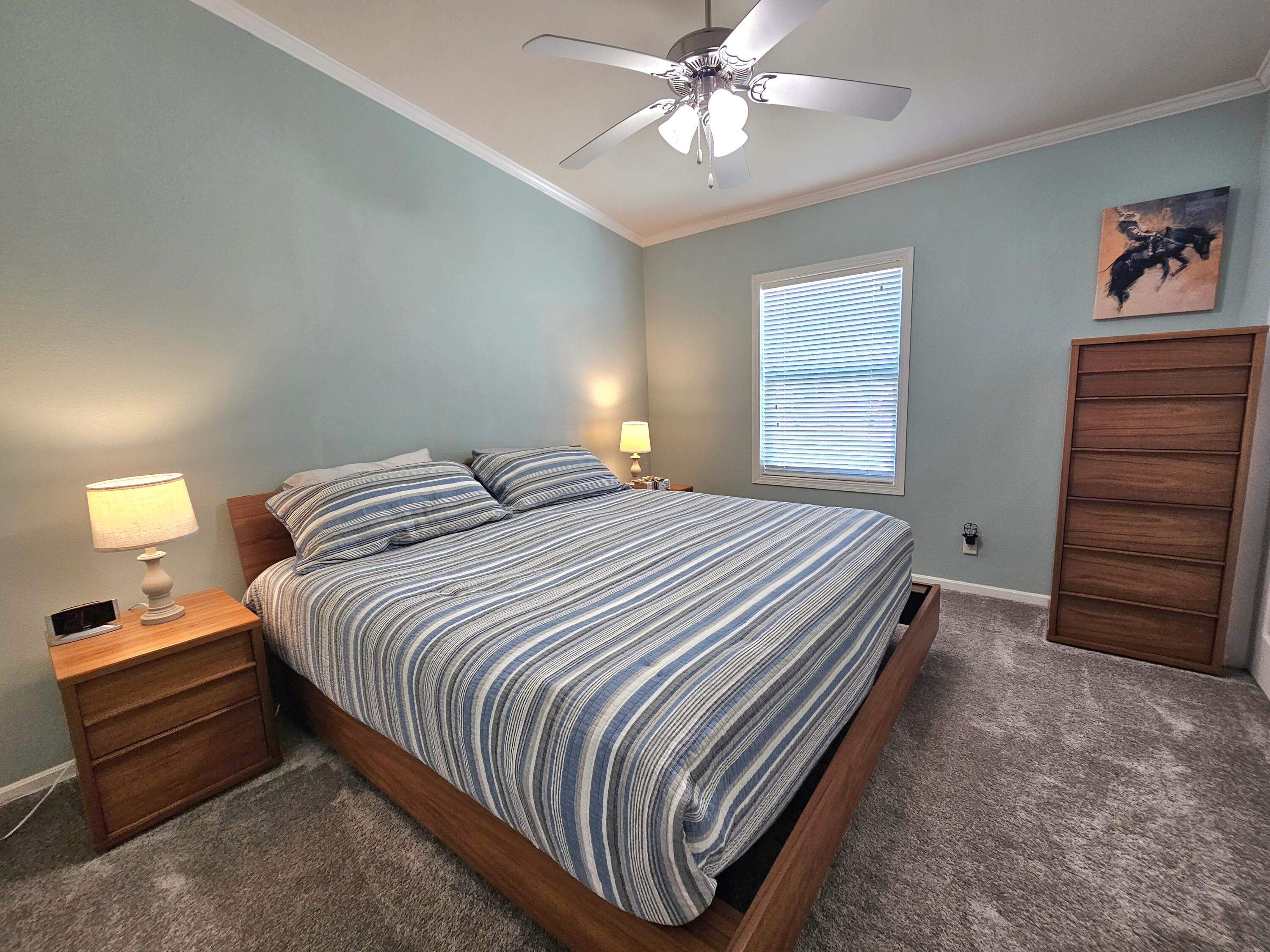 7902 Southeast 95th Trail Okeechobee, FL 34974 - Photo 19 of 36 a bedroom with a bed and a chandelier