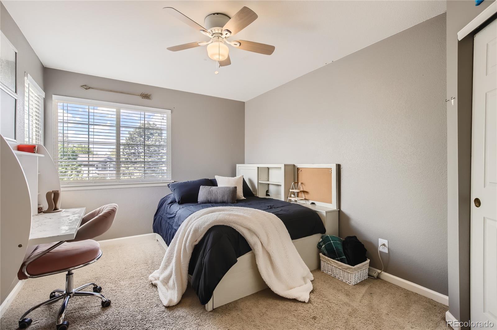 8481 West 95th Drive Westminster, CO 80021 - Photo 15 of 28 a bedroom with a bed and a chandelier