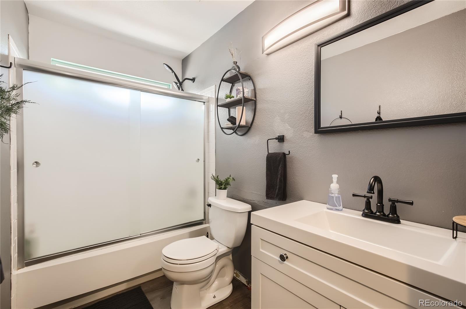 8481 West 95th Drive Westminster, CO 80021 - Photo 16 of 28 a bathroom with a granite countertop toilet sink and mirror