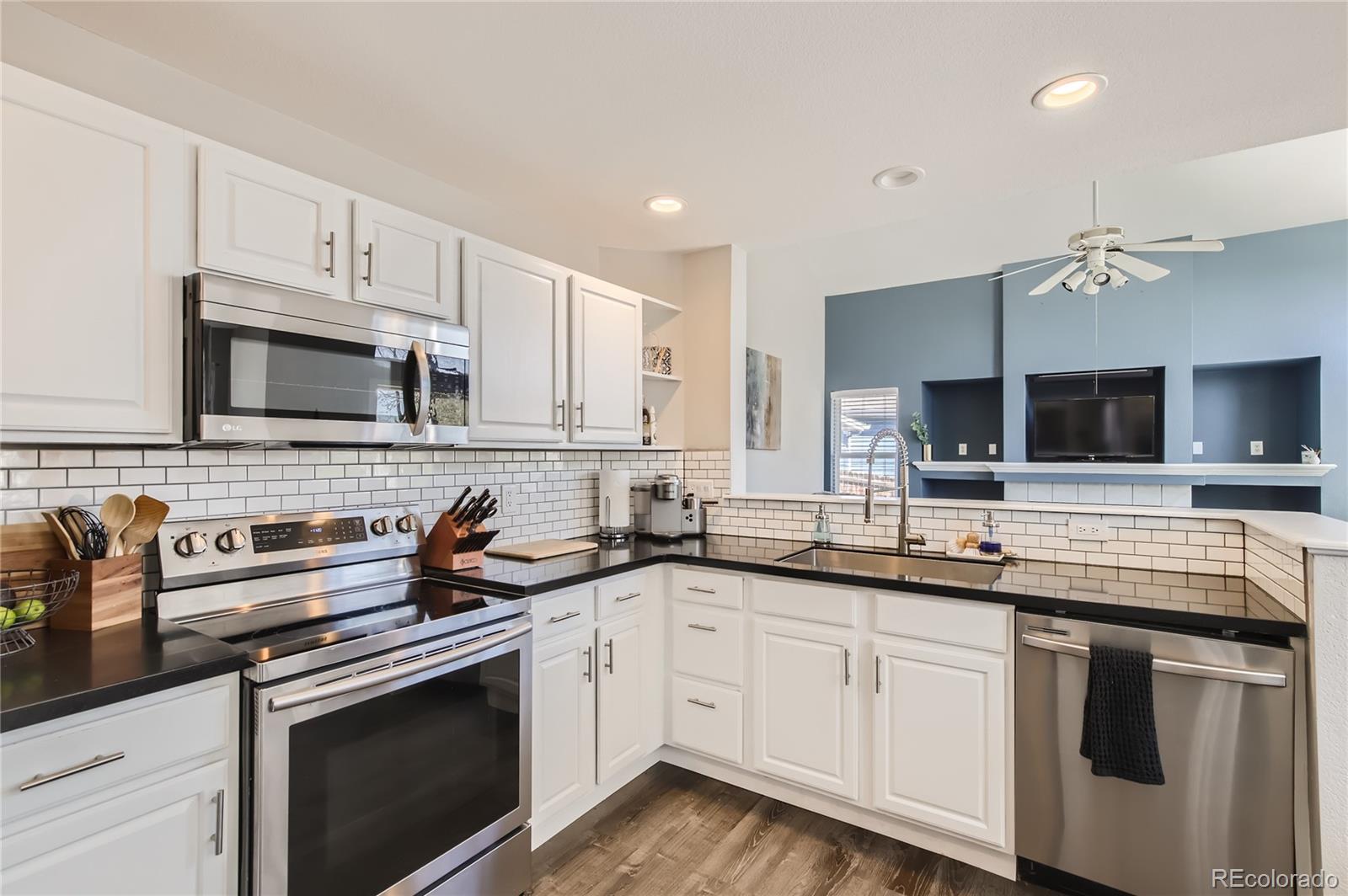 8481 West 95th Drive Westminster, CO 80021 - Photo 2 of 28 a kitchen with stainless steel appliances granite countertop a sink and cabinets