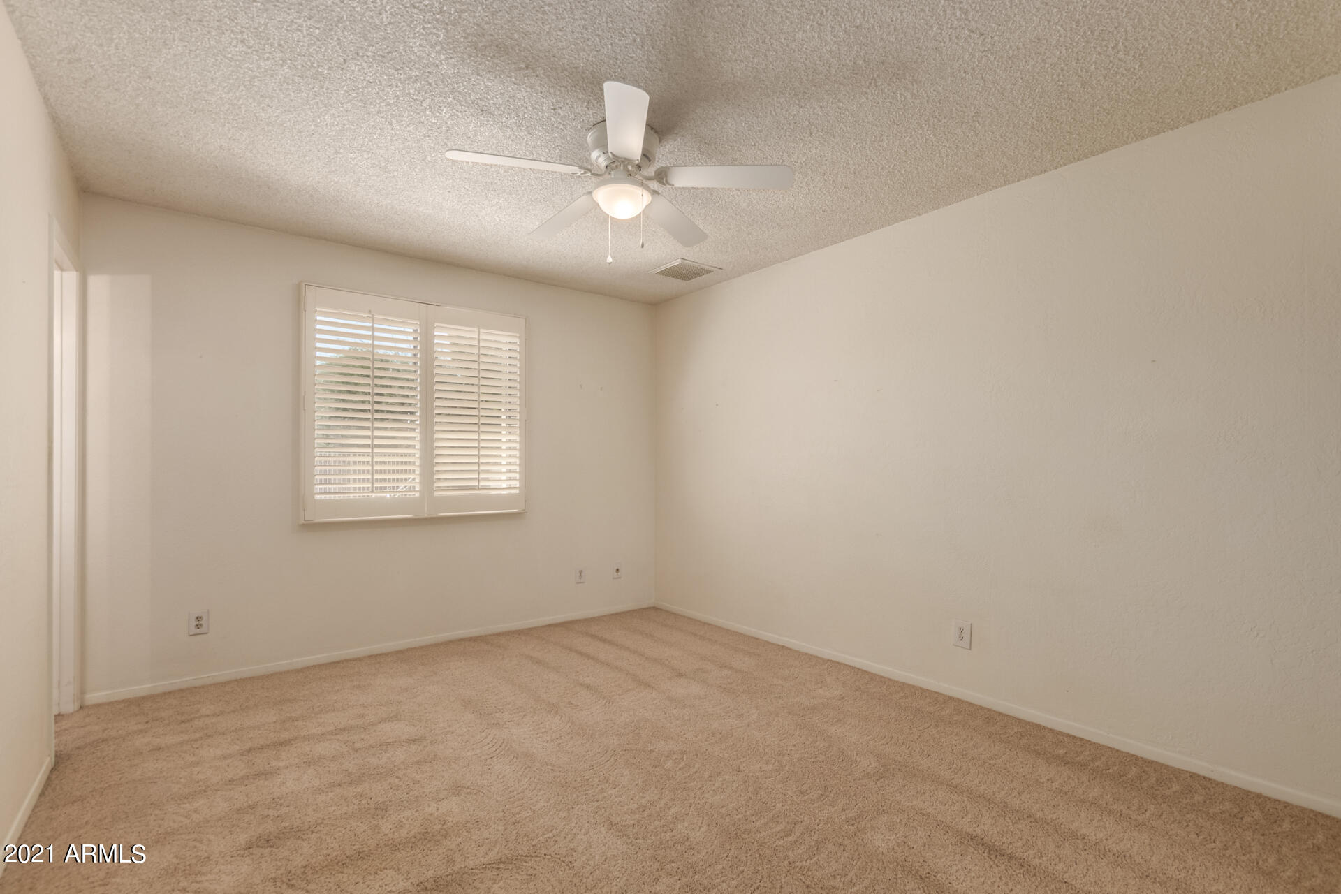 3308 South Newberry Road Tempe, AZ 85282 - Photo 18 of 38 an empty room with a chandelier fan and windows