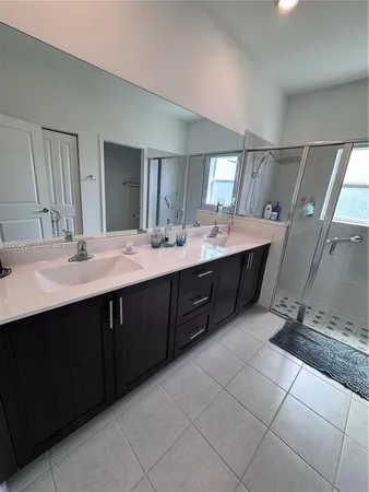 a en suite bathroom with a double vanity sink a mirror and a bathtub