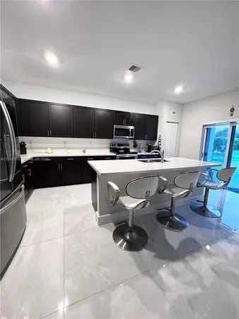 a kitchen with a sink a counter top space appliances and cabinets