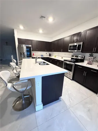 a large kitchen with cabinets table and chairs