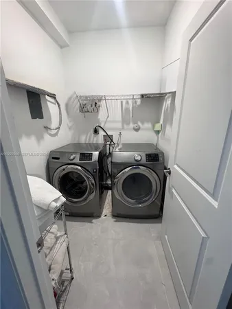 a utility room with dryer washer and a view of living room