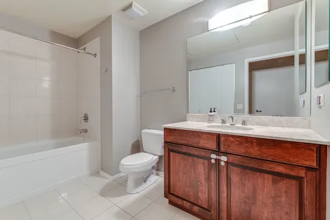 a bathroom with a sink a toilet a mirror a bathtub and shower