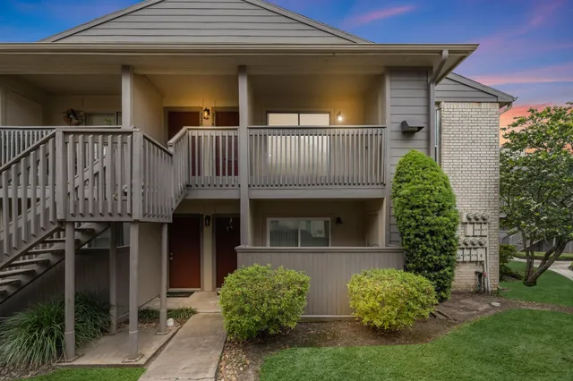 a view of a house with brick walls and a yard with plants