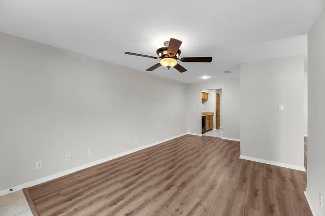 a view of an empty room with wooden floor