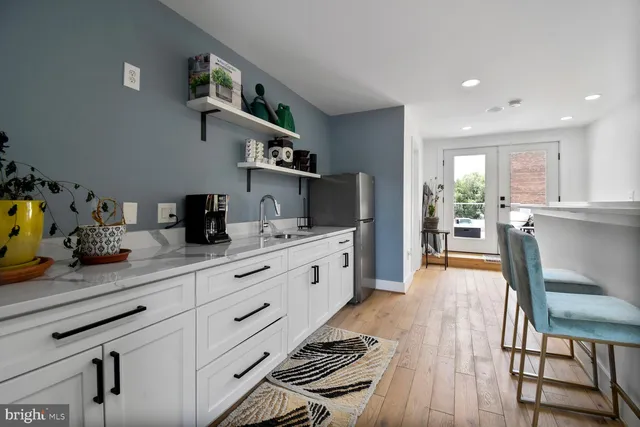 a kitchen with stainless steel appliances kitchen island granite countertop a sink cabinets and wooden floor